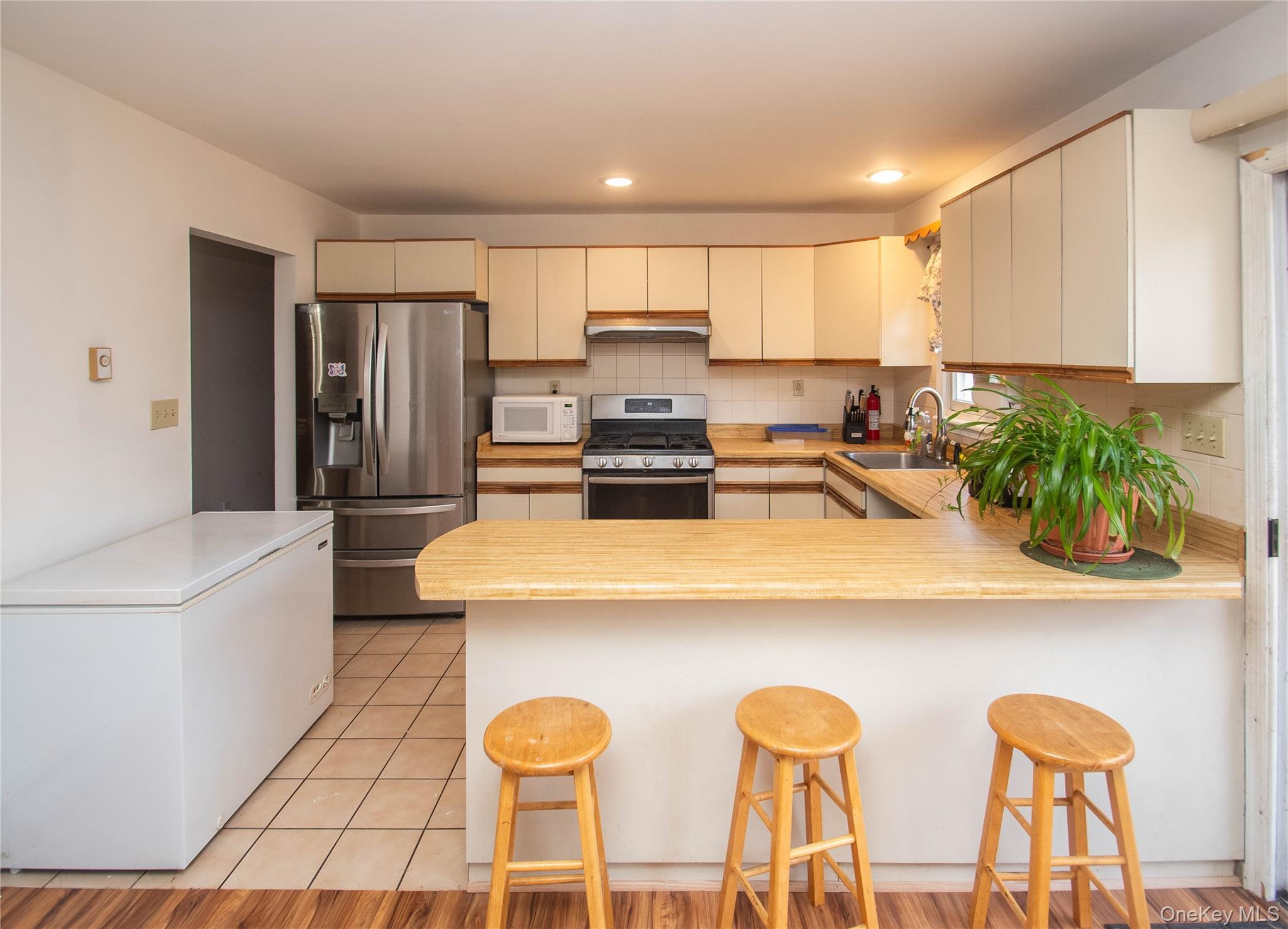 20 Valley Road Forestburgh, NY 12777 - Photo 10 of 38 Kitchen featuring light countertops, backsplash, stainless steel appliances, a peninsula, and a kitchen breakfast bar