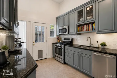 a kitchen with cabinets stainless steel appliances and a sink