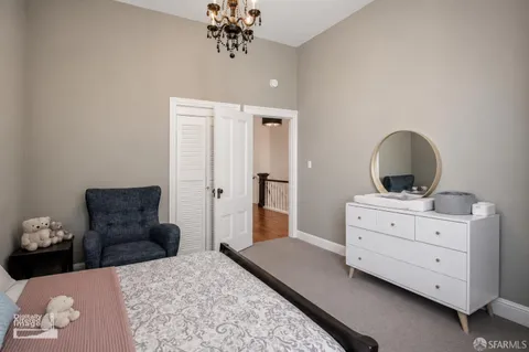 a bedroom with bed tv and couch