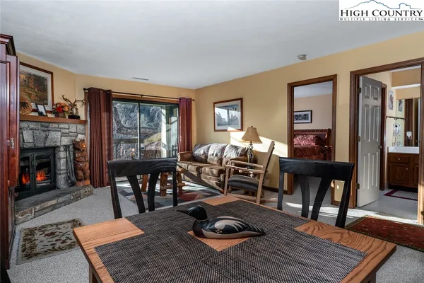 a living room with furniture a fireplace and a dining table with wooden floor