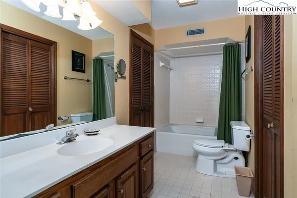 a bathroom with a double vanity sink toilet and shower