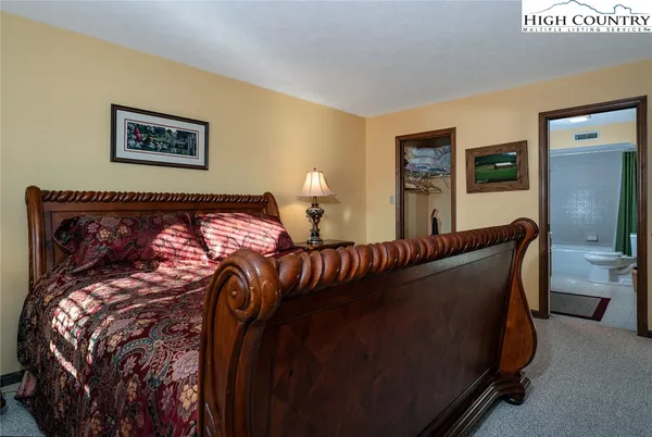 a bedroom with a large bed and a tv on dresser