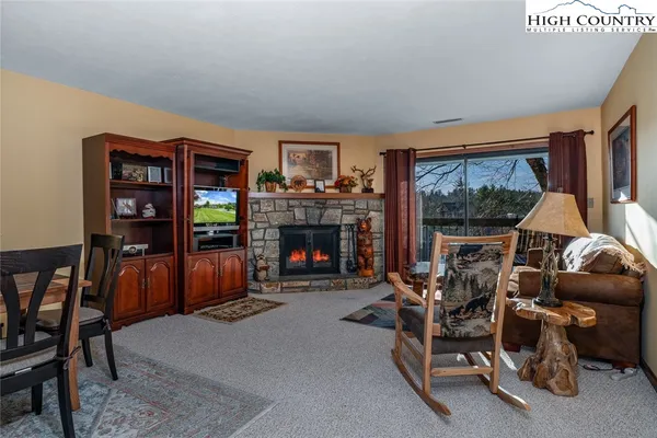 a living room with furniture a floor to ceiling window and a fireplace