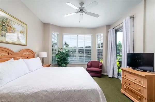 a bedroom with a bed flat screen tv and a window
