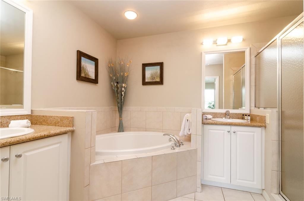 7920 Mahogany Run Lane, Unit 1011 Naples, FL 34113 - Photo 6 of 22 a bathroom with a granite countertop tub sink and mirror