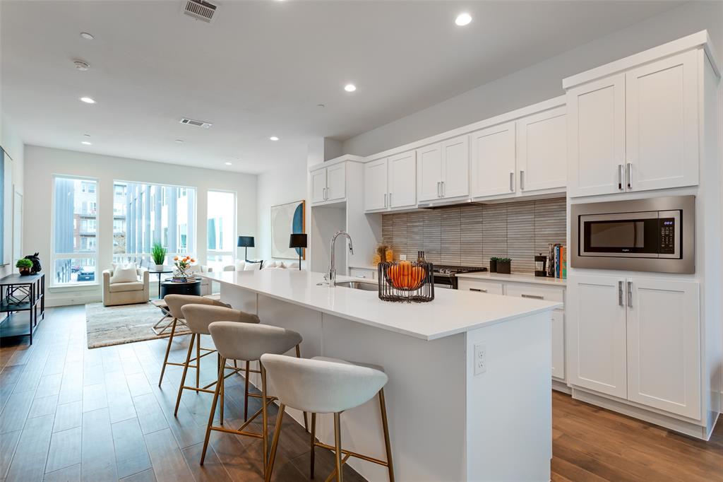 a kitchen with a sink a microwave and cabinets