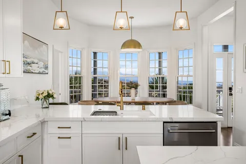 a kitchen with a sink a counter top space and living room view