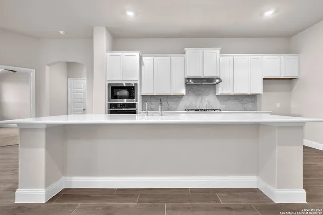 a kitchen with stainless steel appliances granite countertop a refrigerator and a stove