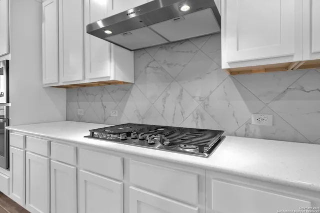 a kitchen with white cabinets and appliances