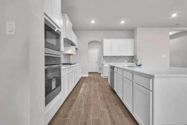 a kitchen with cabinets and wooden floor
