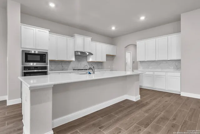a kitchen with a sink stainless steel appliances and white cabinets
