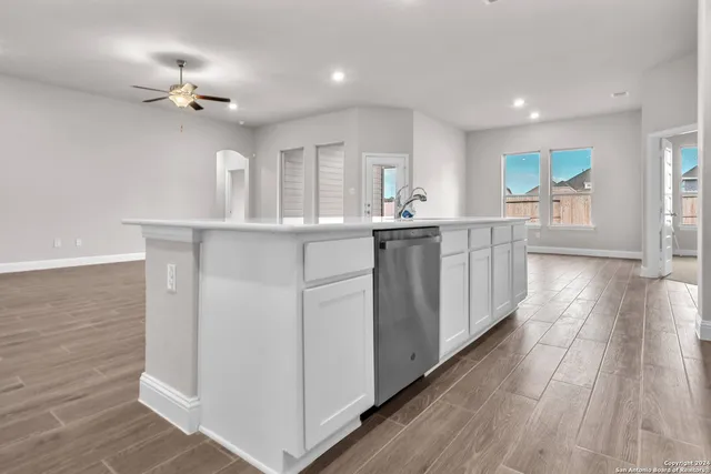a kitchen with stainless steel appliances granite countertop a white cabinets and wooden floor