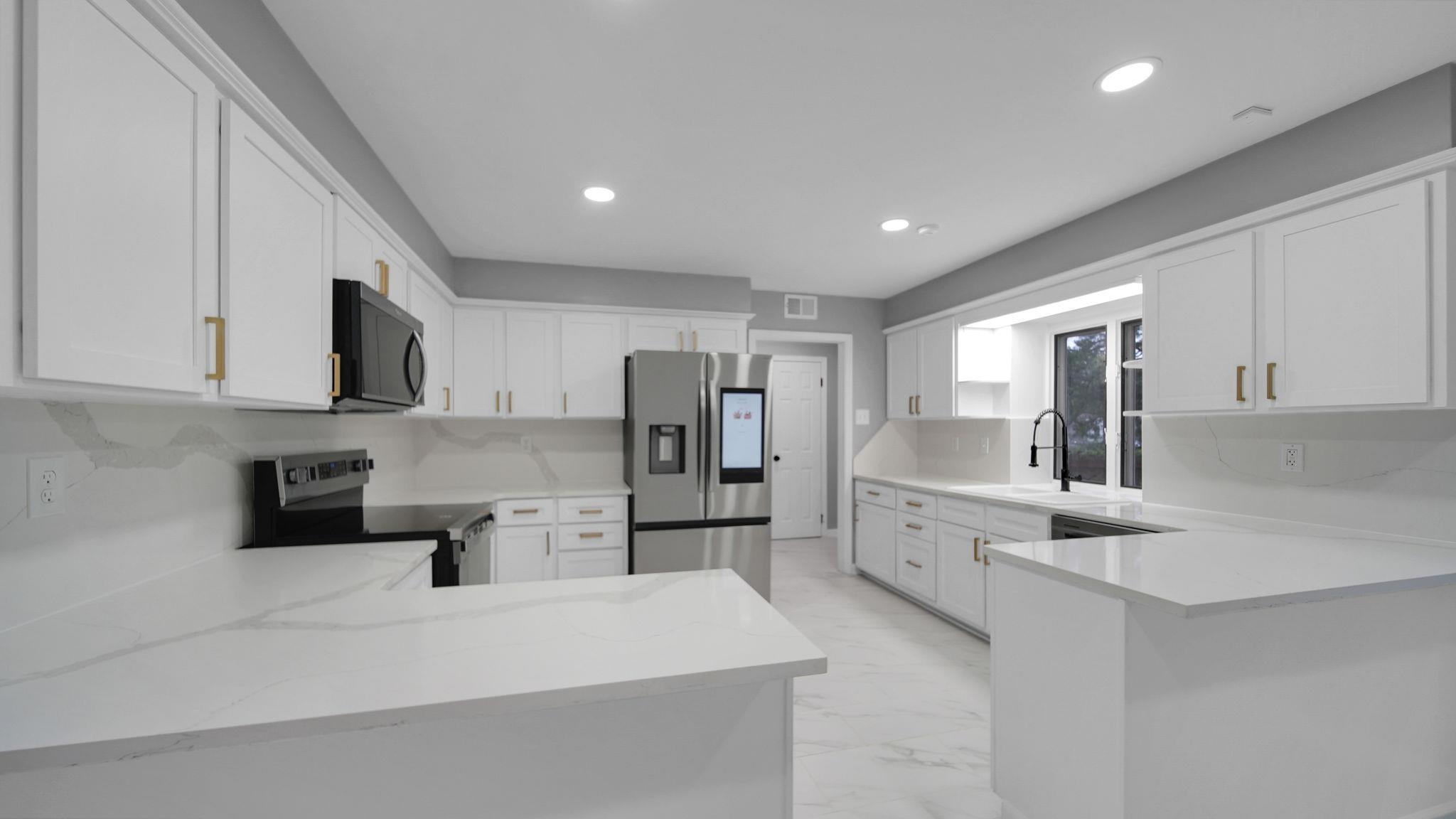 5256 Collingwood Road Memphis, TN 38117 - Photo 13 of 40 Kitchen featuring a peninsula, stainless steel refrigerator with ice dispenser, electric range oven, white cabinetry, and recessed lighting