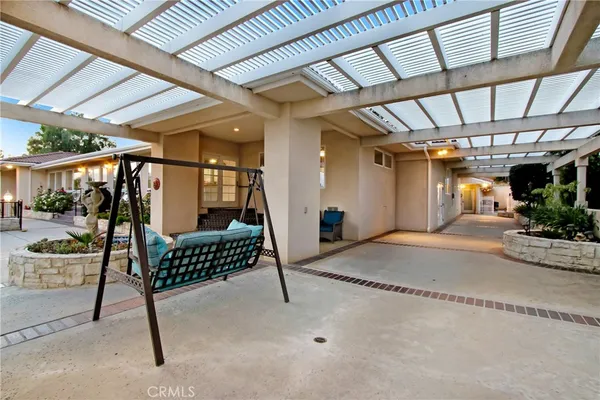 a view of a white building with a tree in front of it