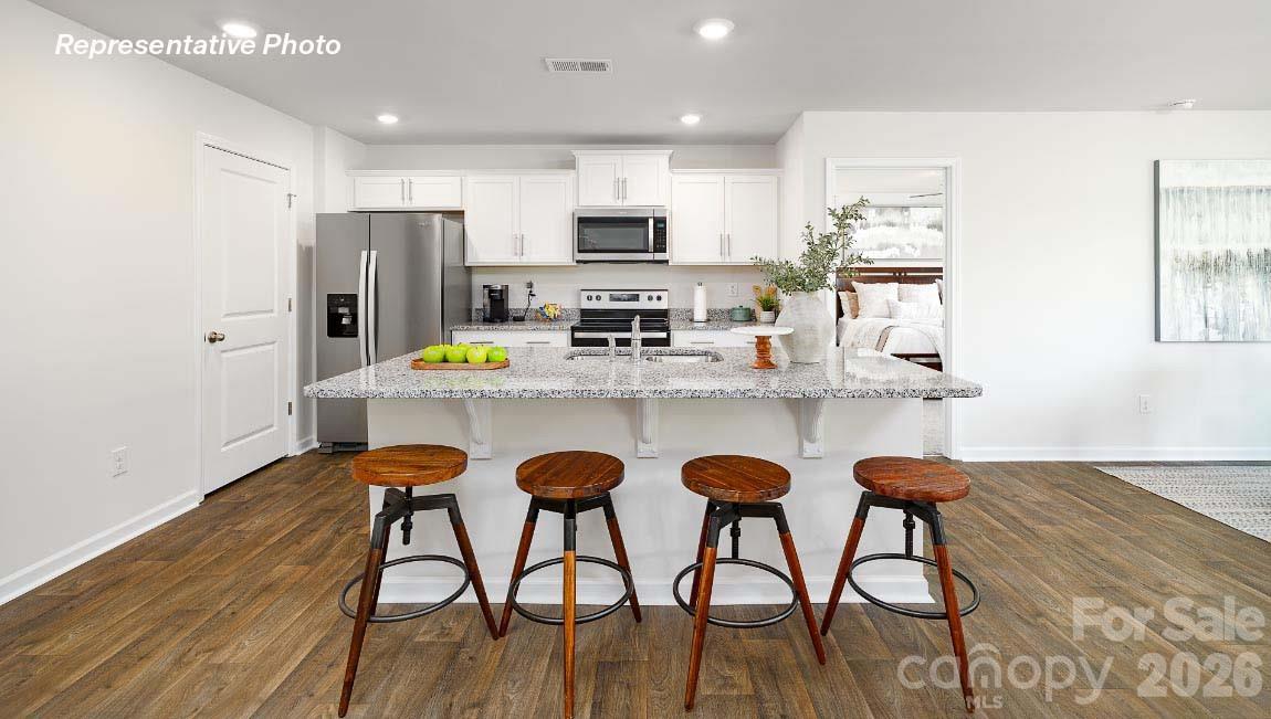 4552 Harris Elliot Road Lincolnton, NC 28092 - Photo 5 of 31 a kitchen with stainless steel appliances granite countertop a dining table chairs refrigerator and sink