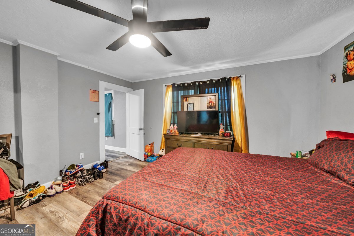 415 East 7th Avenue Cordele, GA 31015 - Photo 11 of 13 a bedroom with a bed and a flat tv screen on dresser
