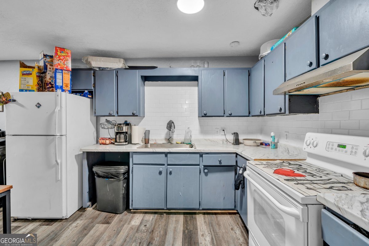 415 East 7th Avenue Cordele, GA 31015 - Photo 7 of 13 a kitchen with a sink a refrigerator and cabinets