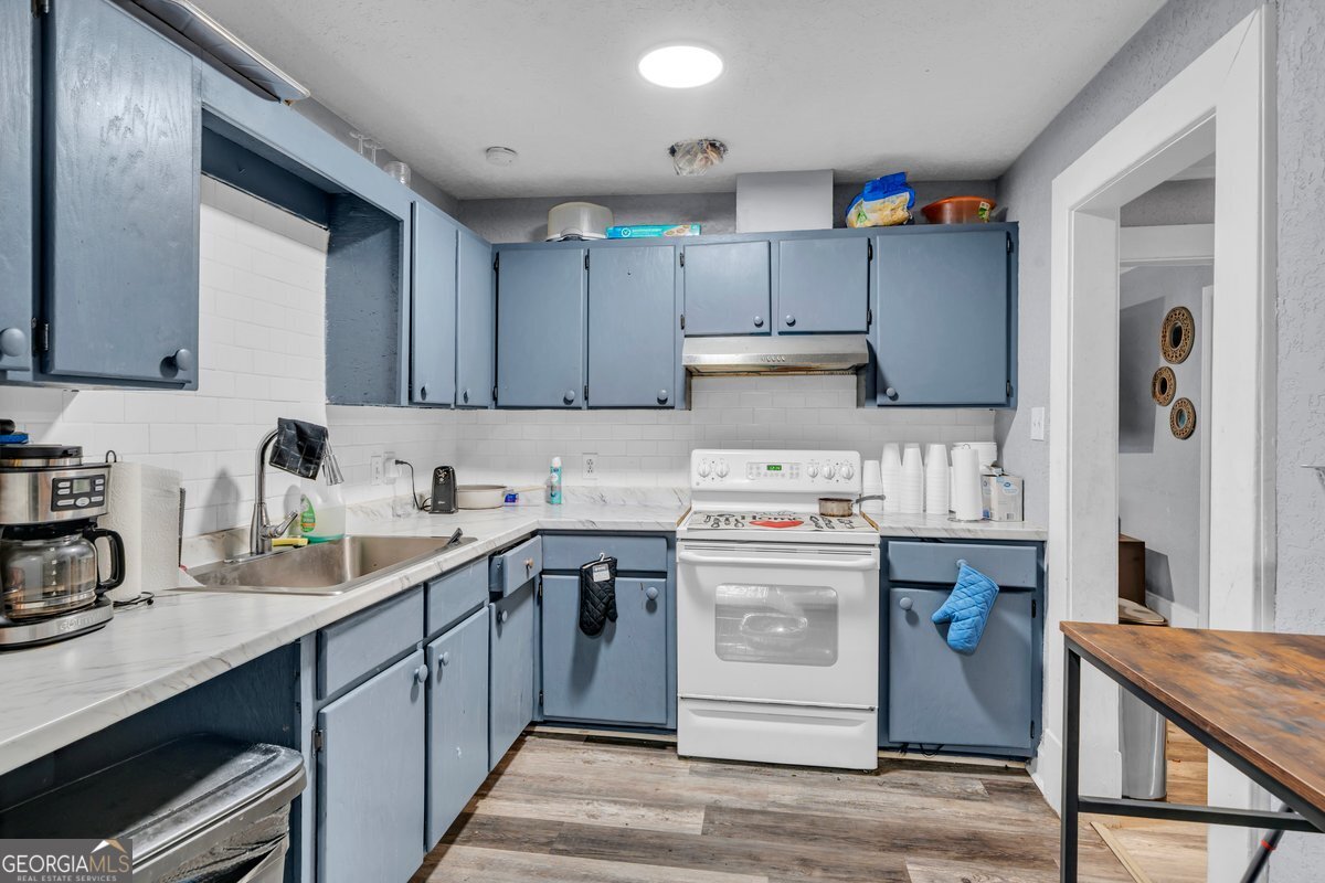 415 East 7th Avenue Cordele, GA 31015 - Photo 8 of 13 a kitchen with a sink a stove and cabinets