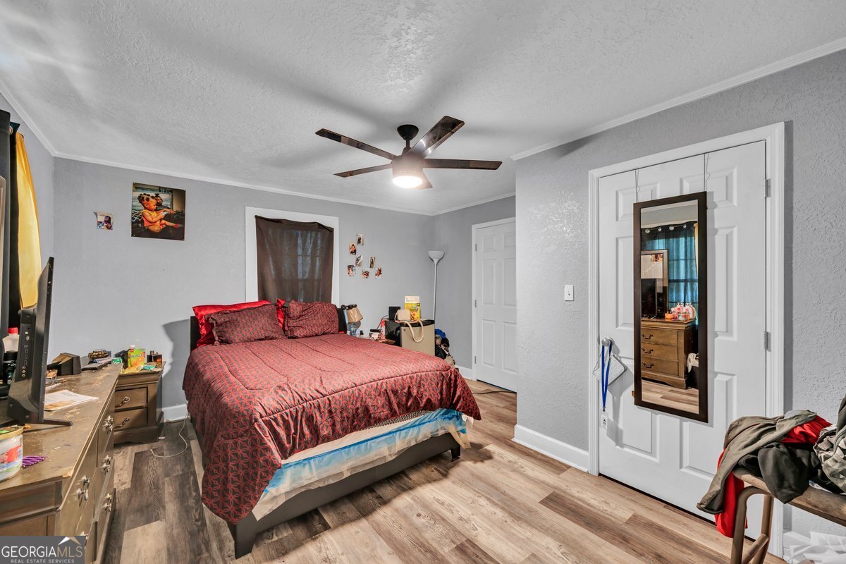 415 East 7th Avenue Cordele, GA 31015 - Photo 9 of 13 a bedroom with a bed and a flat tv screen on the dresser