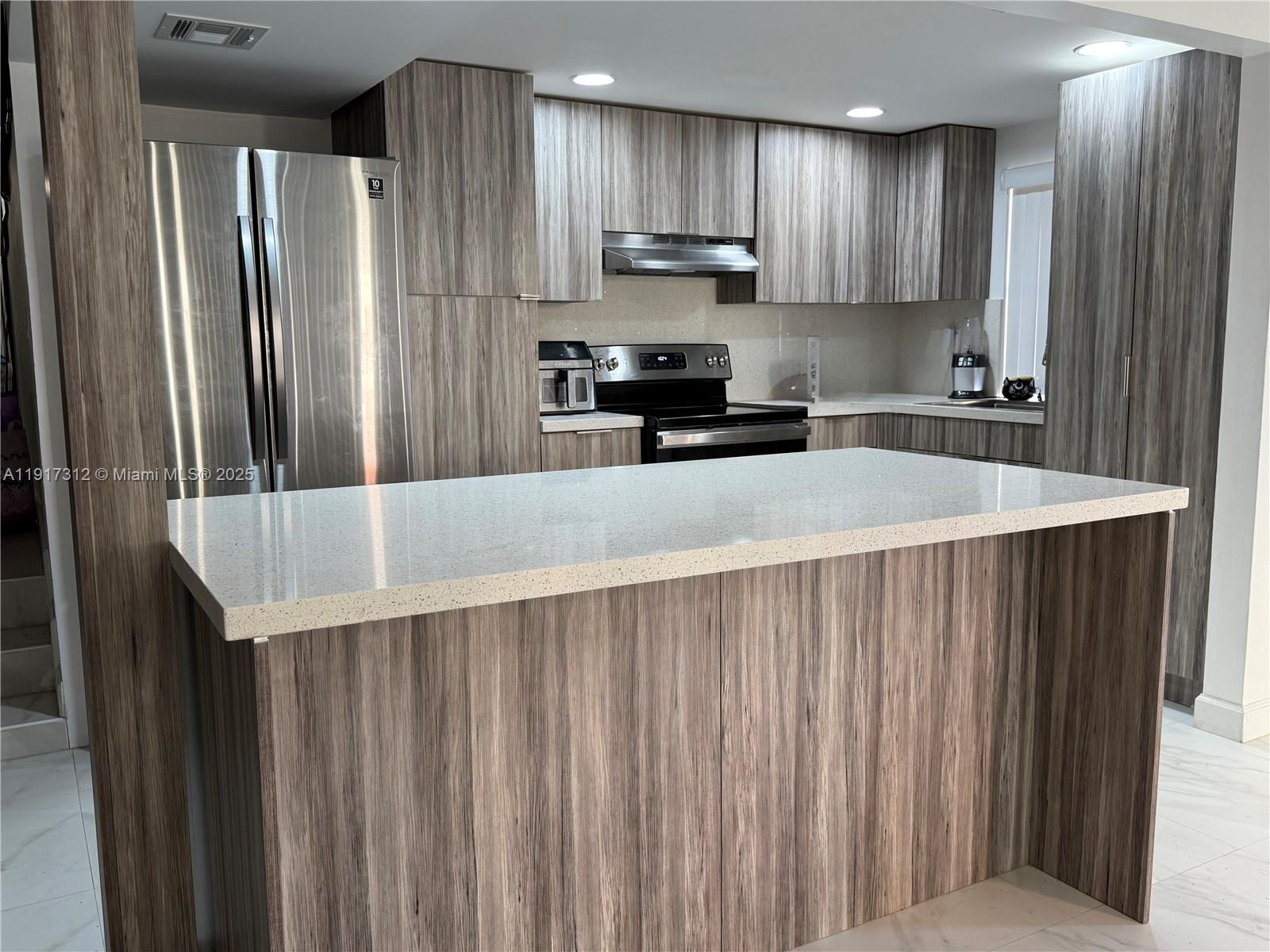 4850 Southwest 63rd Terrace, Unit 312 Davie, FL 33314 - Photo 1 of 27 a kitchen with stainless steel appliances a refrigerator sink and cabinets