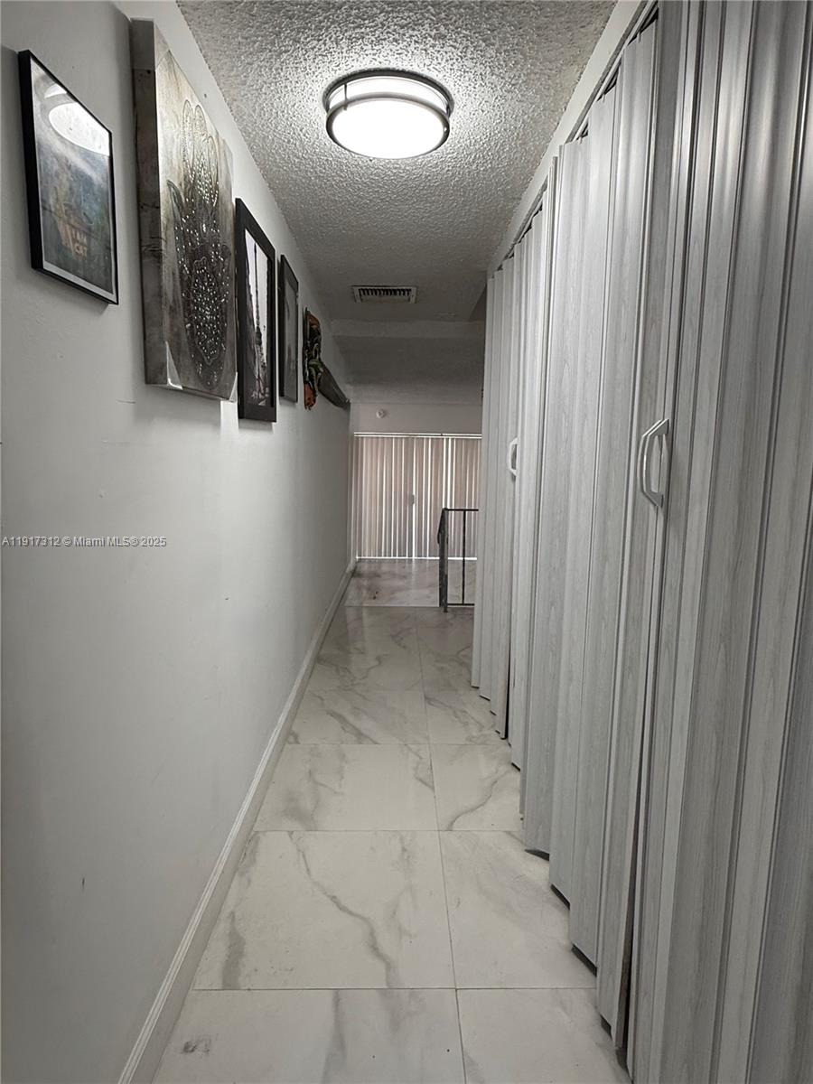4850 Southwest 63rd Terrace, Unit 312 Davie, FL 33314 - Photo 12 of 27 a view of a hallway with wooden floor and stairs
