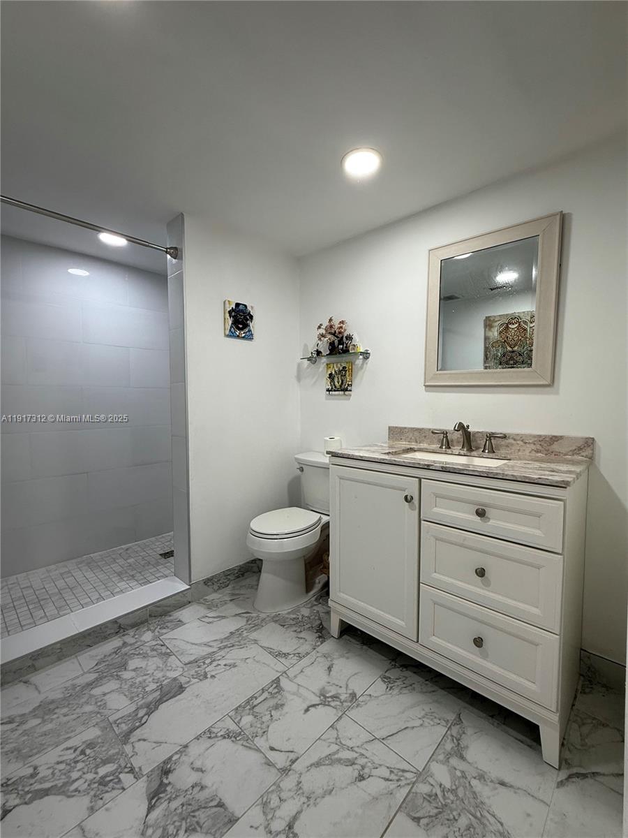 4850 Southwest 63rd Terrace, Unit 312 Davie, FL 33314 - Photo 13 of 27 a spacious bathroom with a toilet sink and mirror
