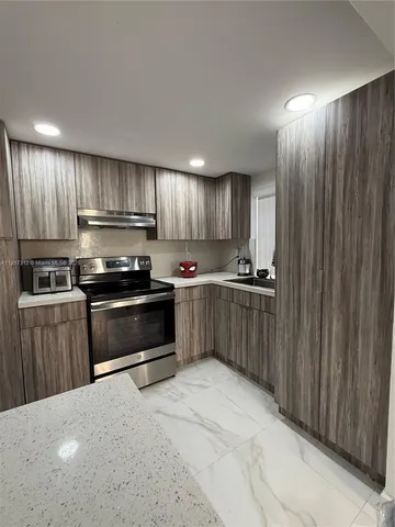 a kitchen with kitchen island granite countertop wooden cabinets and stainless steel appliances