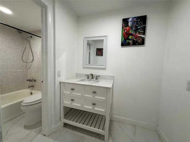a bathroom with a toilet sink vanity tub and shower