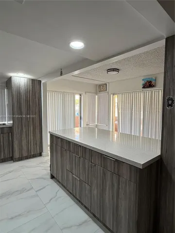 a hallway with a large window and wooden floor