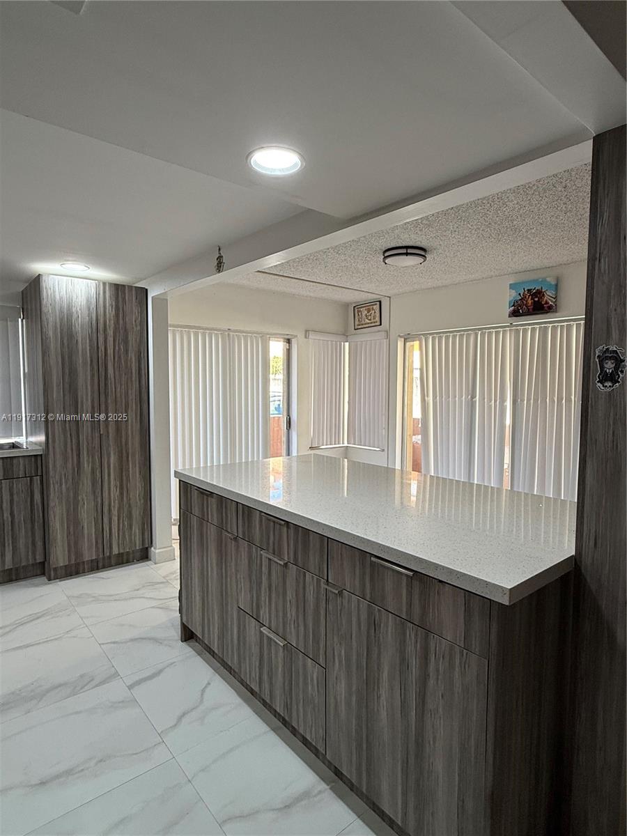 4850 Southwest 63rd Terrace, Unit 312 Davie, FL 33314 - Photo 5 of 27 a hallway with a large window and wooden floor