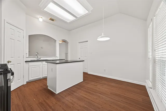 a view of kitchen with granite countertop cabinets and wooden floor