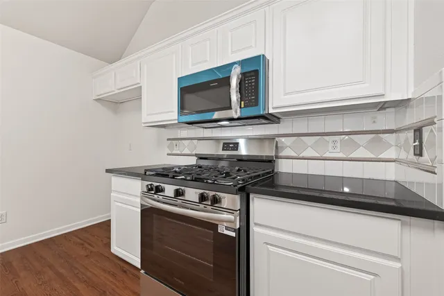 a kitchen with stainless steel appliances granite countertop a stove microwave and sink