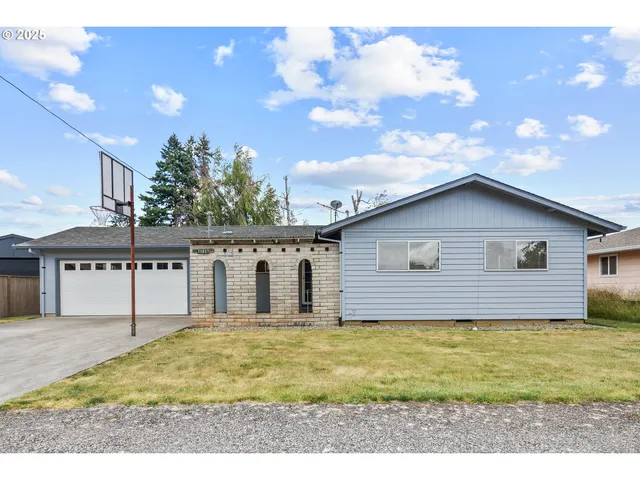 a view of house with backyard and trees