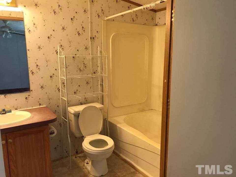 1750 Antioch Church Road Timberlake, NC 27583 - Photo 4 of 10 a bathroom with a granite countertop sink toilet and shower