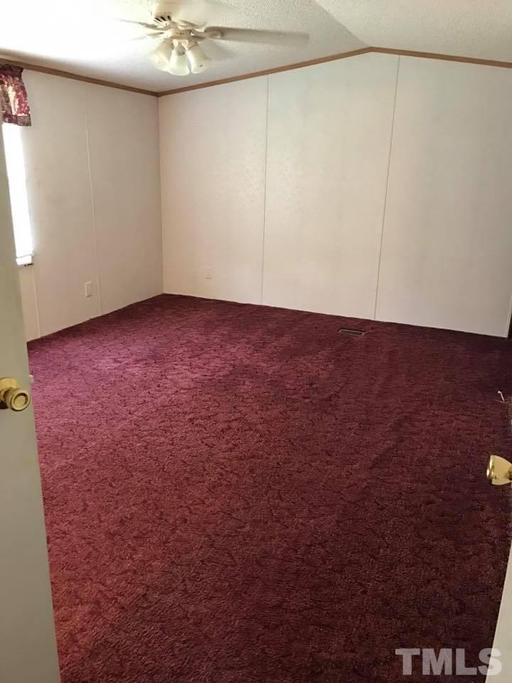 1750 Antioch Church Road Timberlake, NC 27583 - Photo 5 of 10 an empty room with a ceiling fan