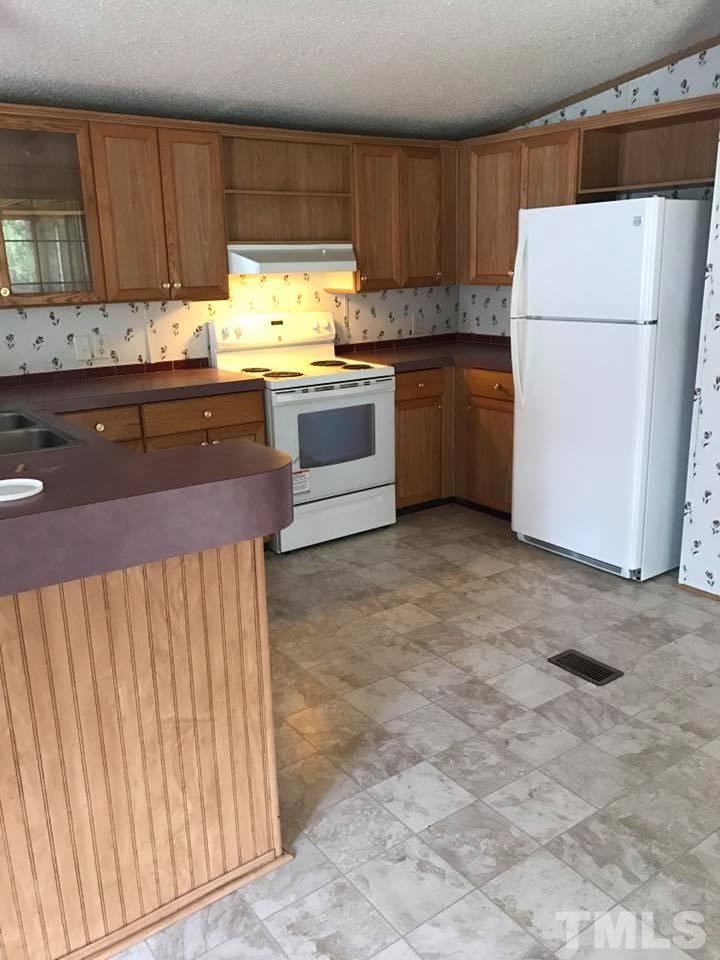 1750 Antioch Church Road Timberlake, NC 27583 - Photo 6 of 10 a kitchen with stainless steel appliances granite countertop a refrigerator sink and cabinets