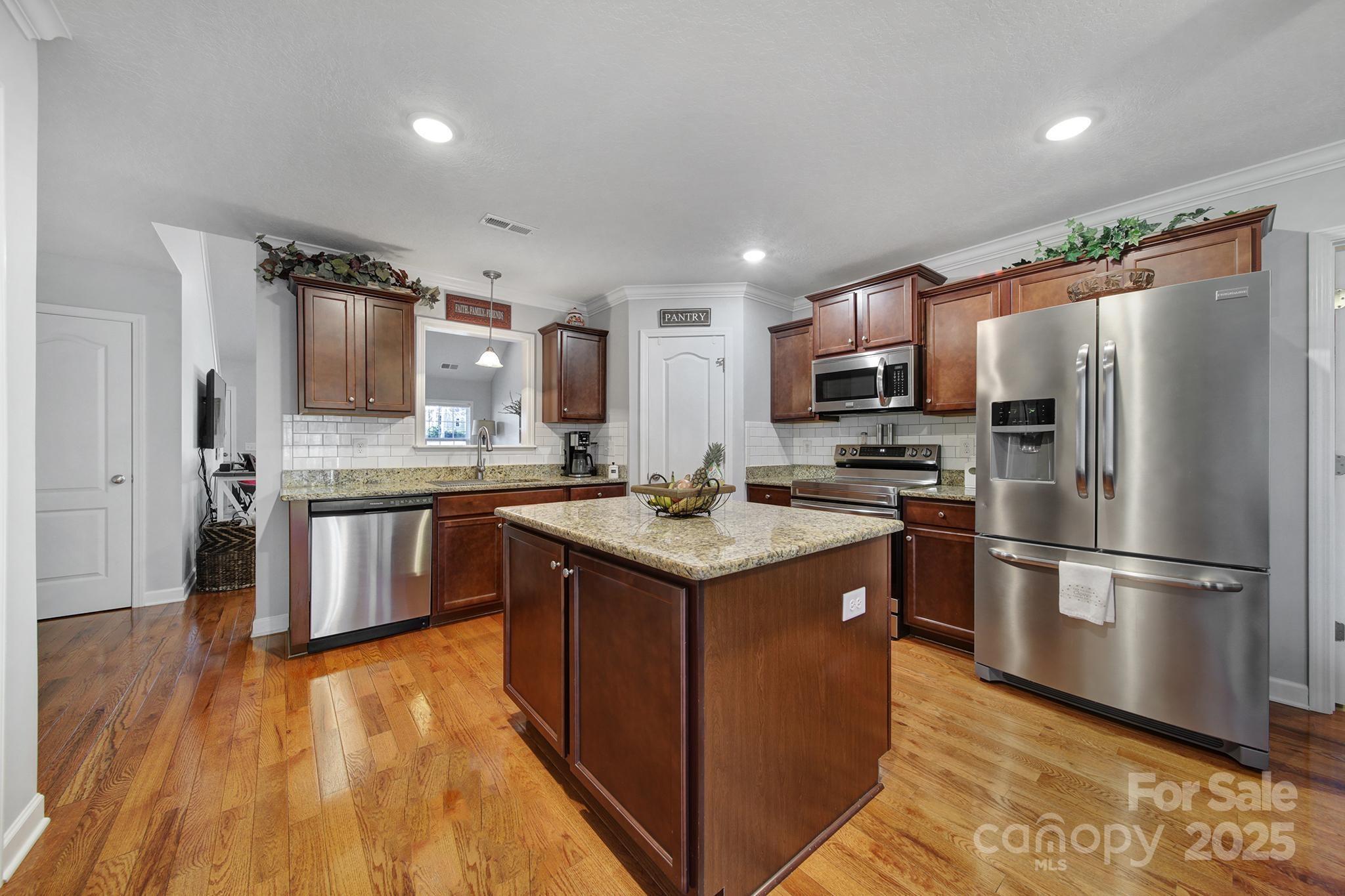 2045 Roadrunner Road Clover, SC 29710 - Photo 6 of 38 a kitchen with stainless steel appliances granite countertop a stove top oven a refrigerator and a microwave