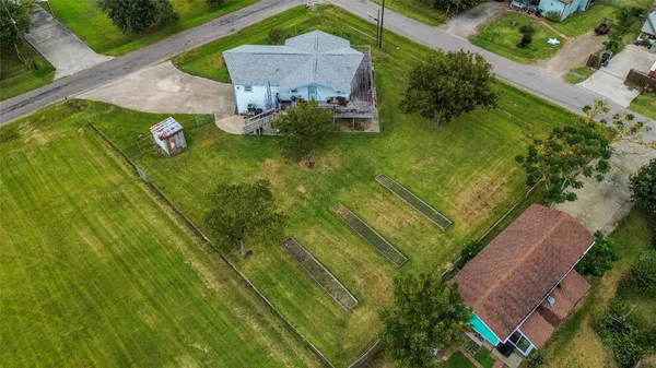 an aerial view of residential houses with outdoor space and trees