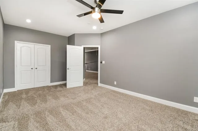 an empty room with closet and a ceiling fan