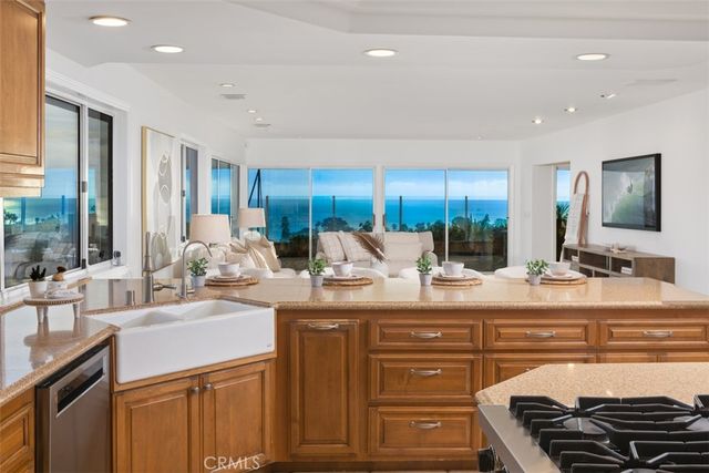 a view of a kitchen with kitchen island granite countertop a sink and cabinets