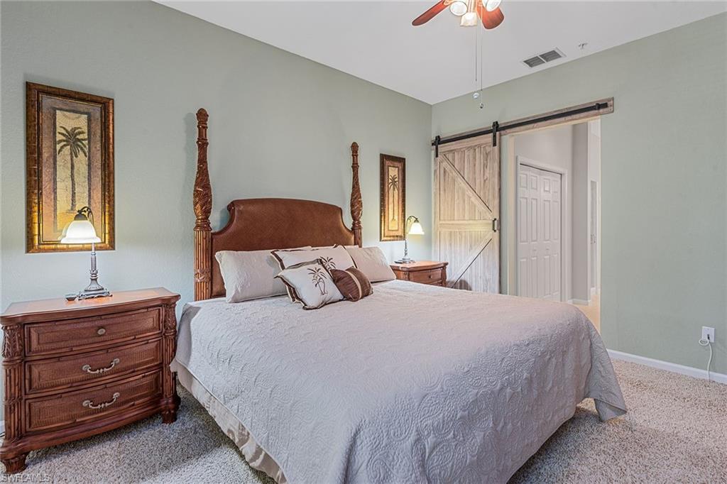 3945 Deer Crossing Court, Unit 203 Naples, FL 34114 - Photo 12 of 50 a bedroom with a bed and a window