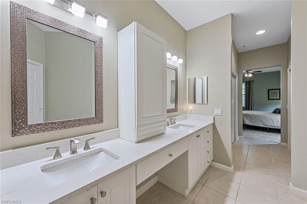 3945 Deer Crossing Court, Unit 203 Naples, FL 34114 - Photo 14 of 50 a en suite bathroom with double sink and a mirror