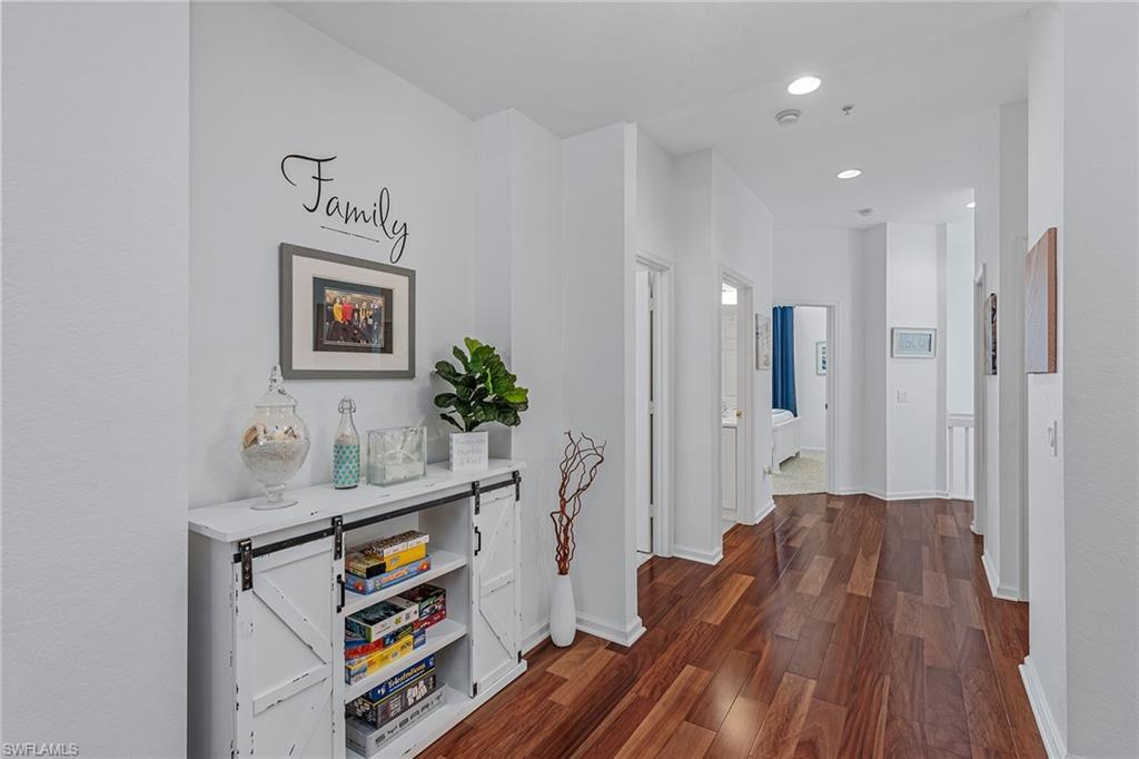 3945 Deer Crossing Court, Unit 203 Naples, FL 34114 - Photo 18 of 50 a hallway with wooden floor and furniture