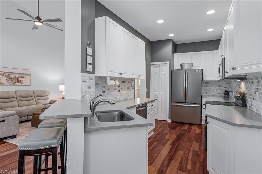 3945 Deer Crossing Court, Unit 203 Naples, FL 34114 - Photo 2 of 50 a kitchen with kitchen island a sink stove and refrigerator