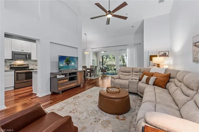 a living room with furniture a flat screen tv and kitchen view