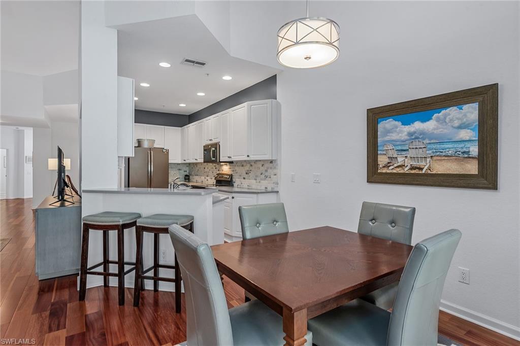 3945 Deer Crossing Court, Unit 203 Naples, FL 34114 - Photo 7 of 50 a open dining room with furniture and wooden floor
