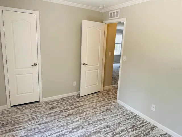 a view of an empty room with wooden floor
