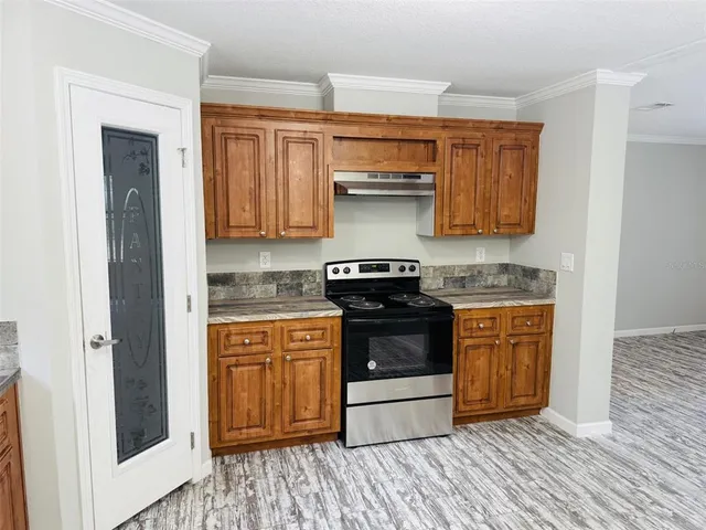 a kitchen with stainless steel appliances granite countertop a stove a sink and a refrigerator