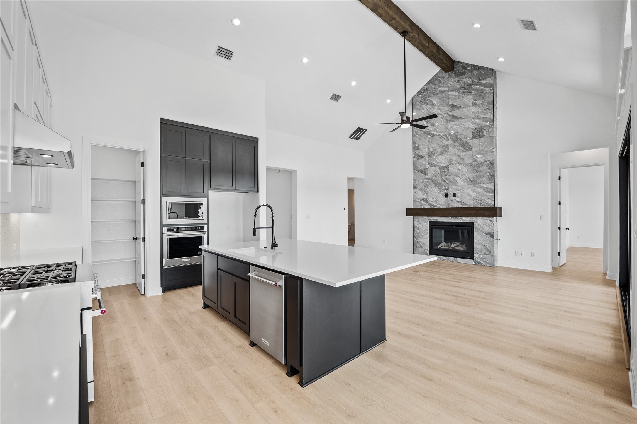 3213 Lookout Mountain Road Georgetown, TX 78628 - Photo 39 of 40 Kitchen with a fireplace, an island with sink, stainless steel appliances, light wood-style floors, and open floor plan
