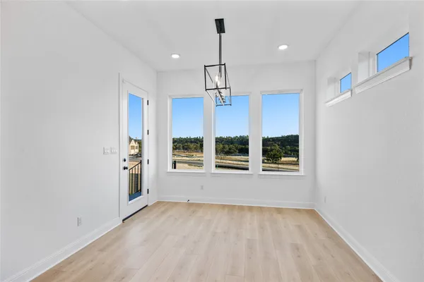 wooden floor fireplace and windows in an empty room